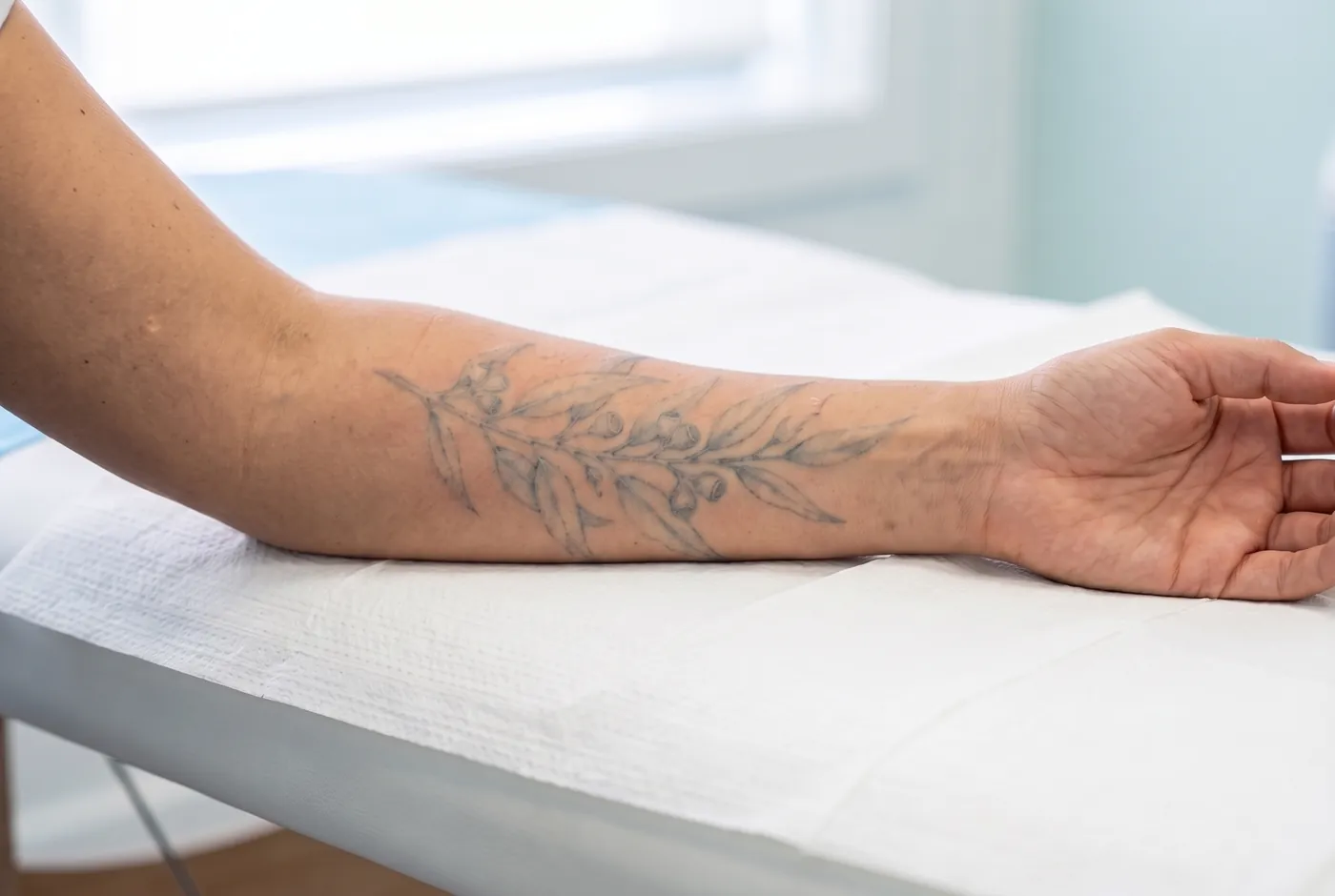 Ilustración: el mismo tatuaje de línea fina, mucho más claro tras varias sesiones, con el contorno todavía visible